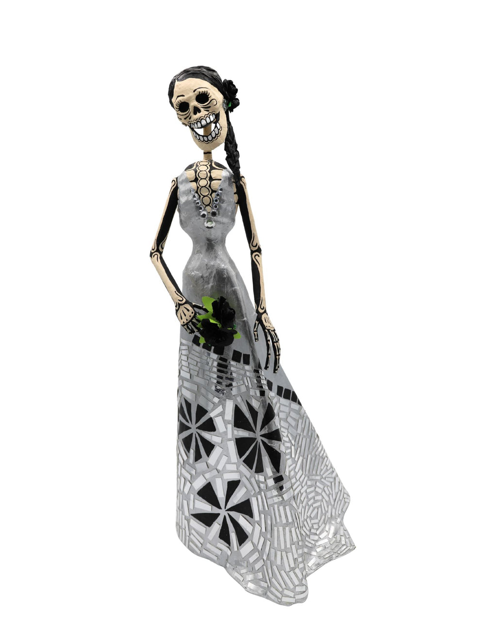 A papier-mâché skeleton figurine wearing a long black and white mosaic-patterned dress