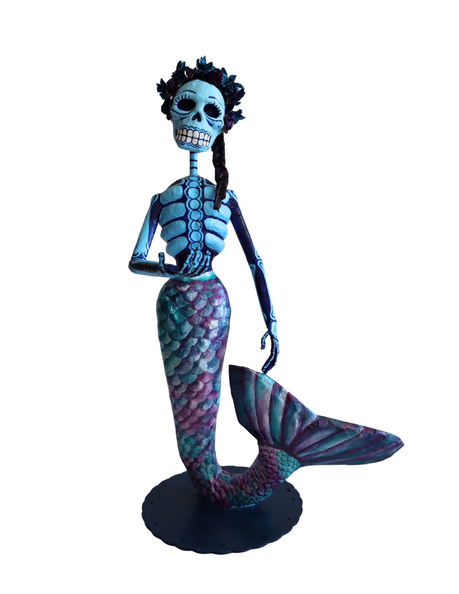 A papier-mâché mermaid skeleton figurine with blue and purple scaled tail.