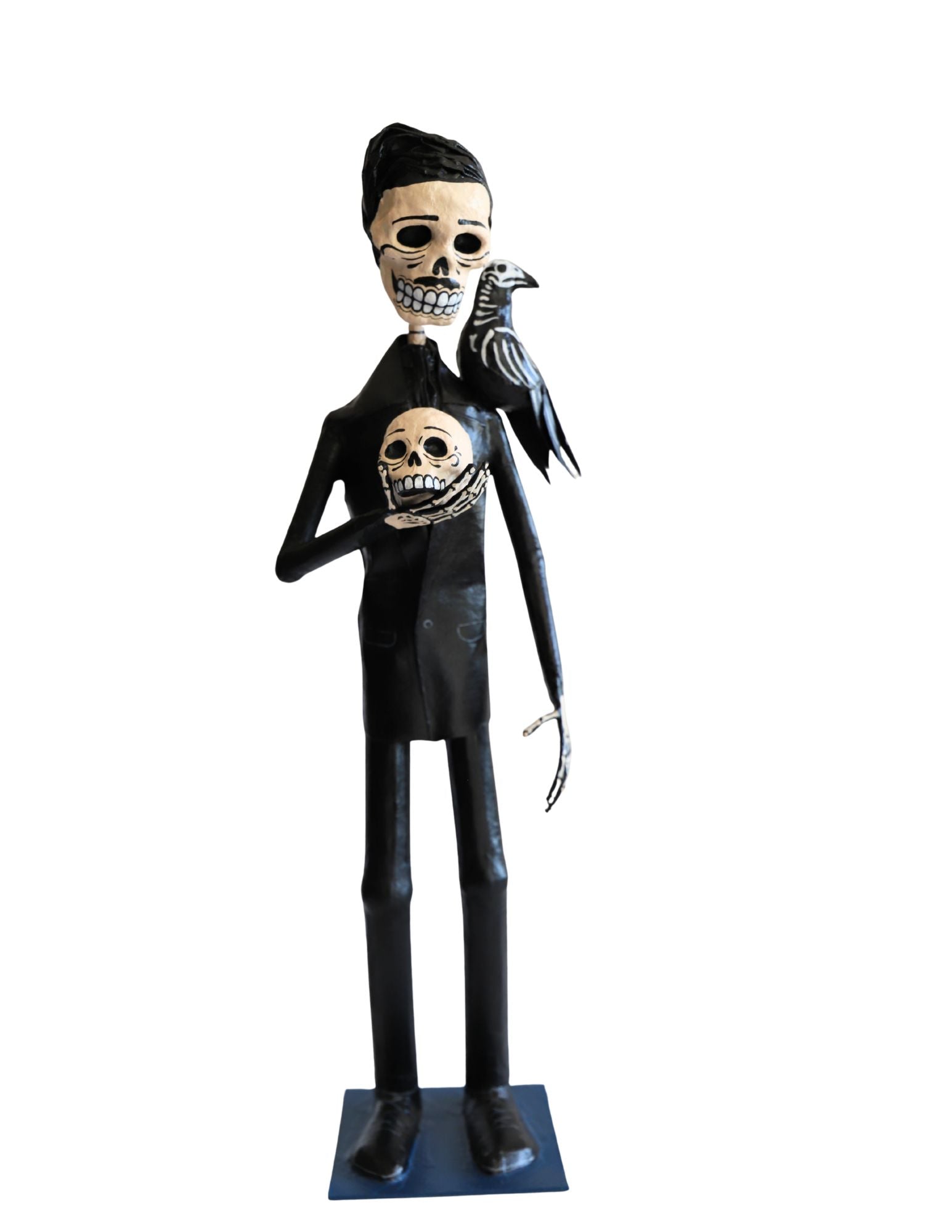 A papier-mâché skeleton figurine wearing a black suit and holding a skull with a black raven on its shoulder.