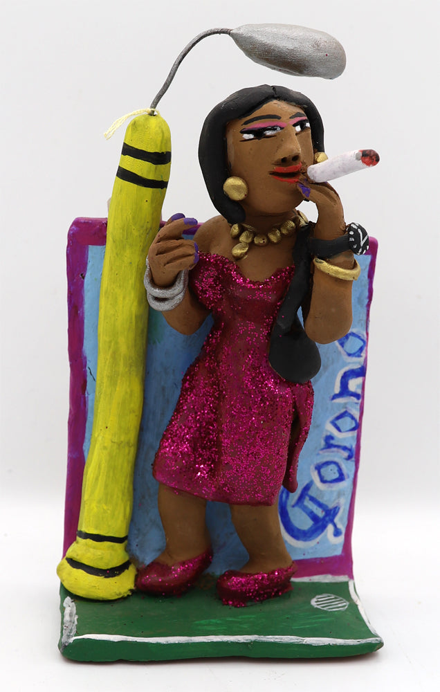 A ceramic figurine of a woman in a sparkly pink dress holding an oversized cigarette under a street light. 