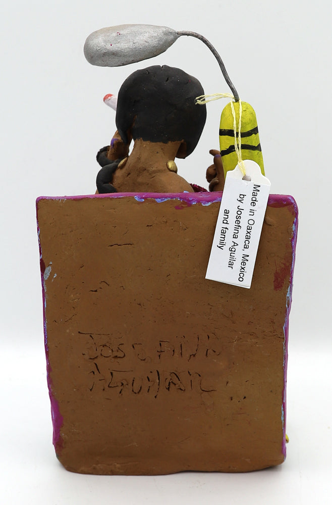 A ceramic figurine of a woman in a sparkly pink dress holding an oversized cigarette under a street light. 
