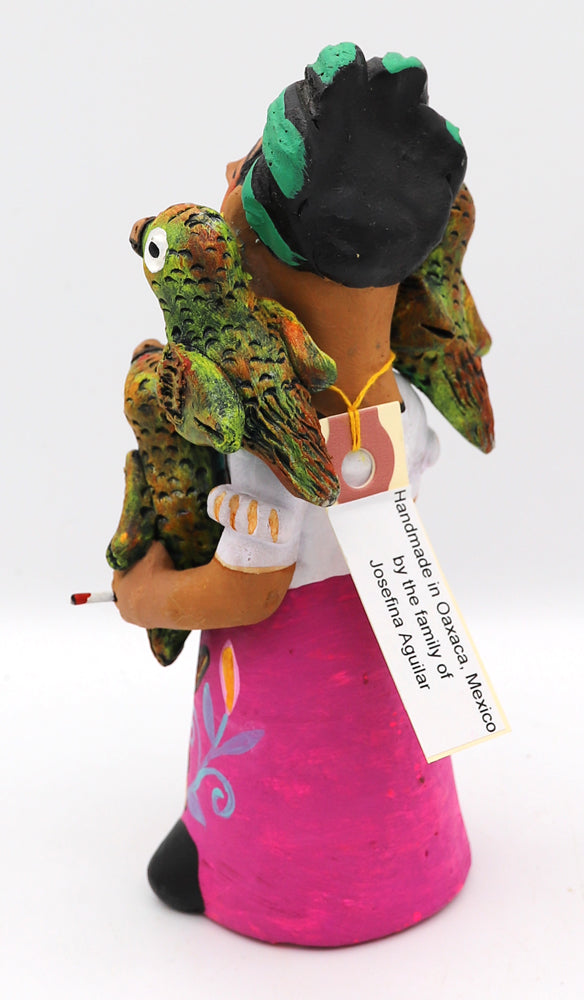 Colorful ceramic figurine of a woman holding parrots.