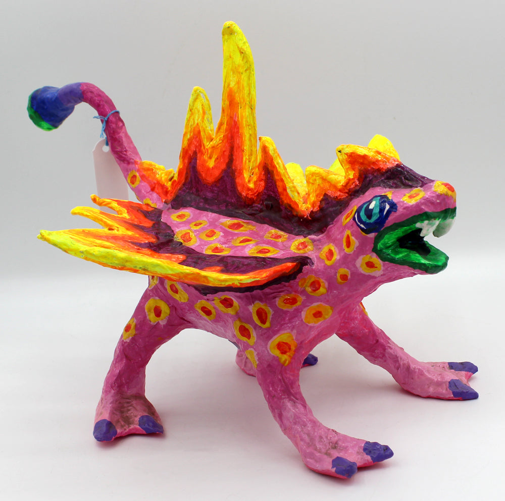 Colorful creature figurine with pink body, yellow spikes, and spots.