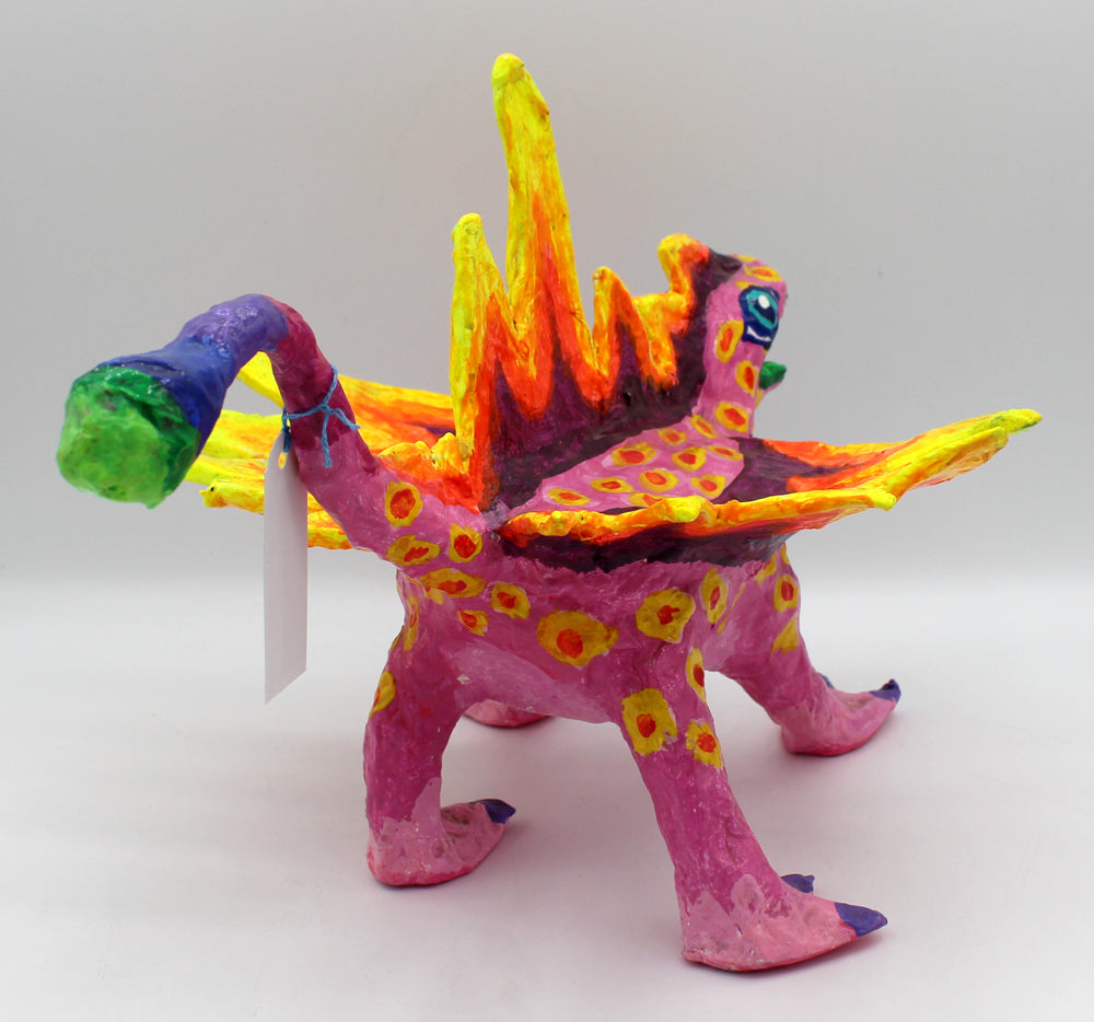 Colorful creature figurine with pink body, yellow spikes, and spots.