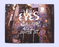 Cover of  'EYES Gallery 402 South St.' book with Julia Zagar standing in the window of a mosaicked wall. 