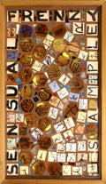 Framed mosaic with the words "sensual frenzy sampler" on it. Small tiles depict various body parts. 