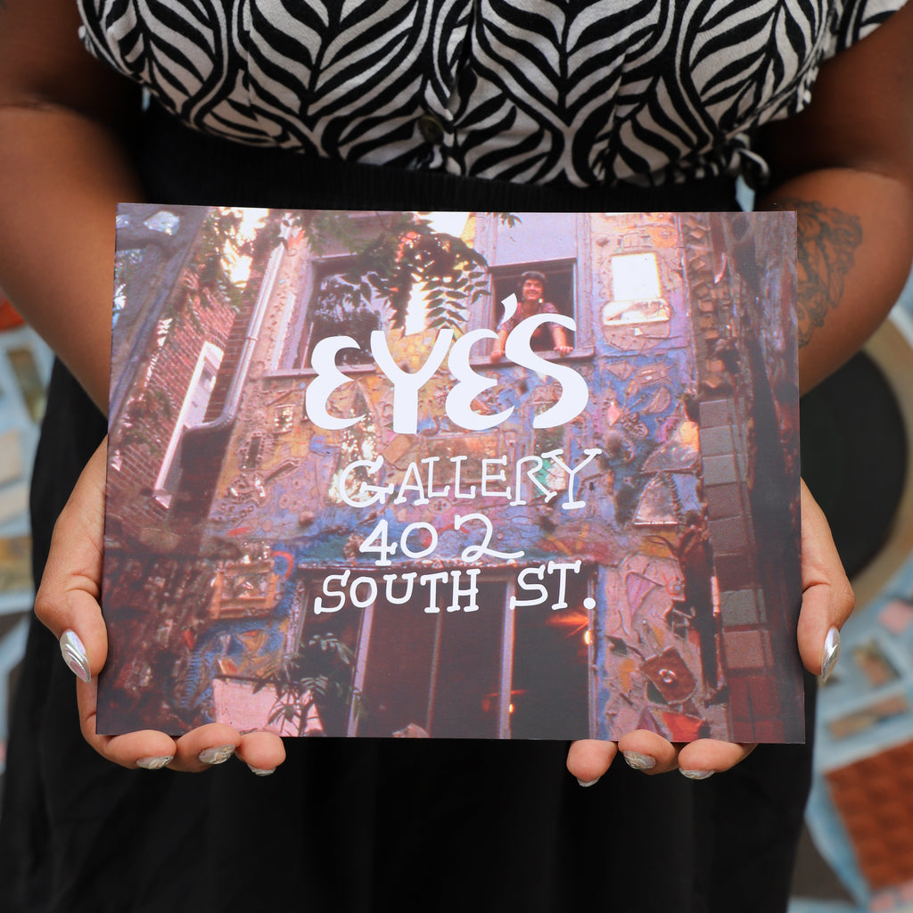 Two hands hold a copy of the book "Eye's Gallery 402 South St."