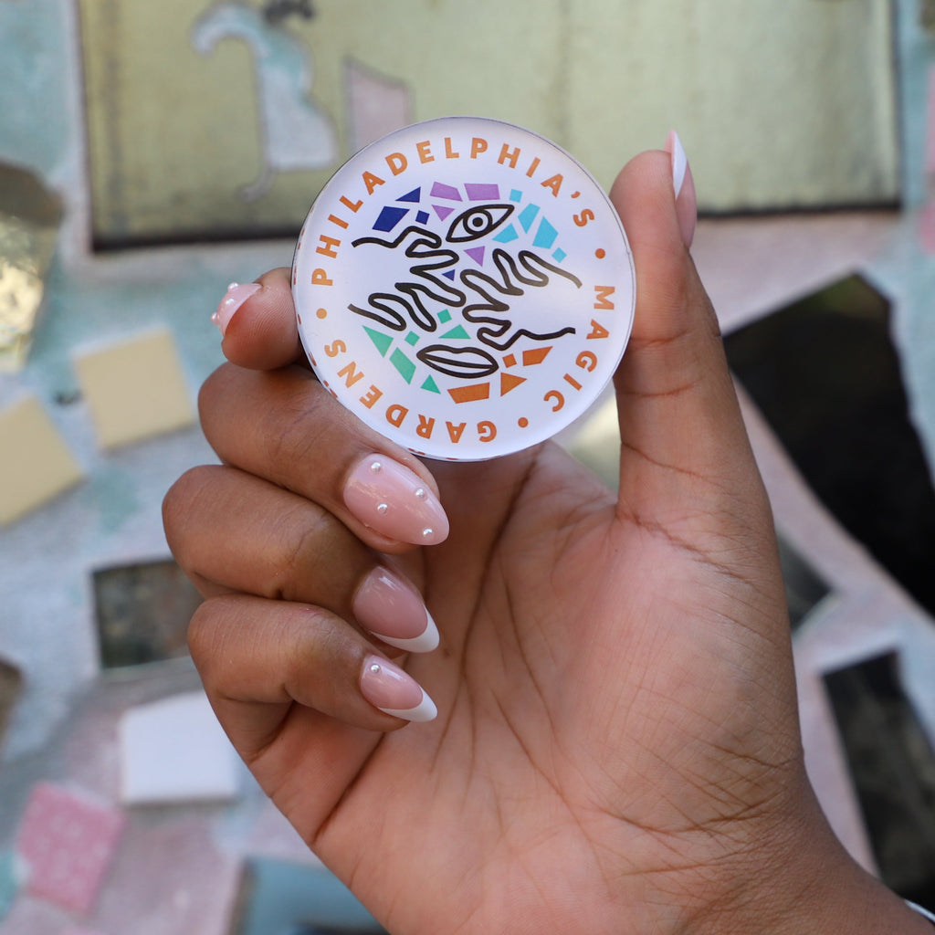 A round refrigerator magnet featuring Philadelphia's Magic Gardens logo