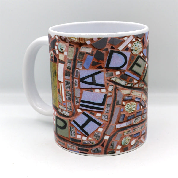 11 oz. ceramic coffee mug featuring an image of the "Philadelphia" mosaic by Isaiah Zagar and Philadelphia's Magic Gardens logo.