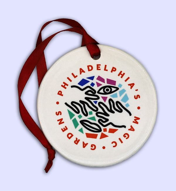 2.75" diameter round porcelain ornament with 4" red ribbon loop.  Back side features the logo of Philadelphia's Magic Gardens.