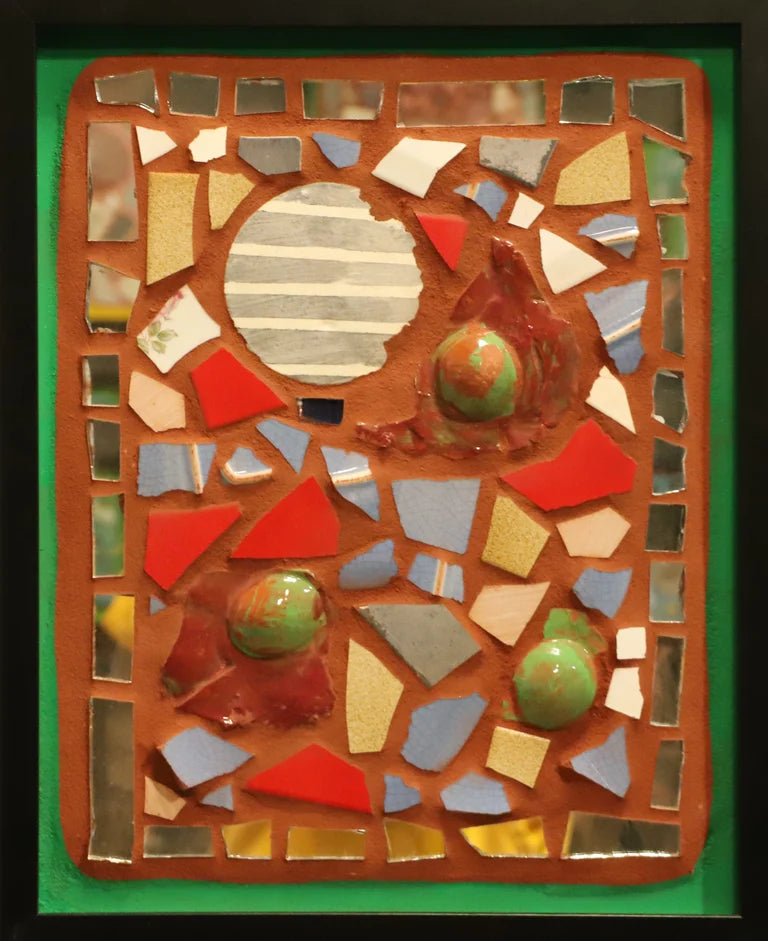 Framed mosaic with several round tiles on an orange background with a green border.