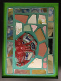 Framed mosaic with colorful tiles and mirror and a green border